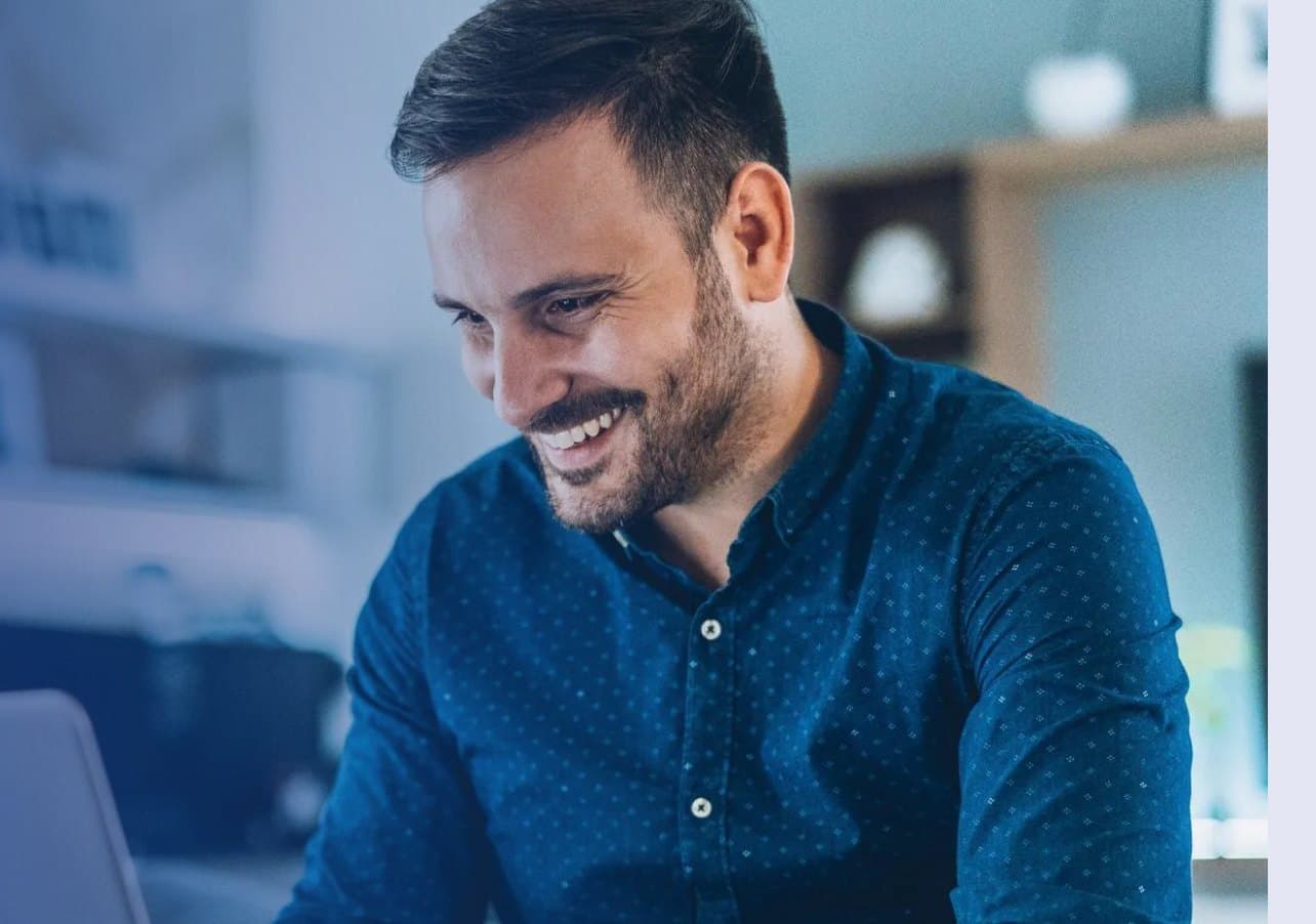 Empresário sorrindo enquanto trabalha no notebook